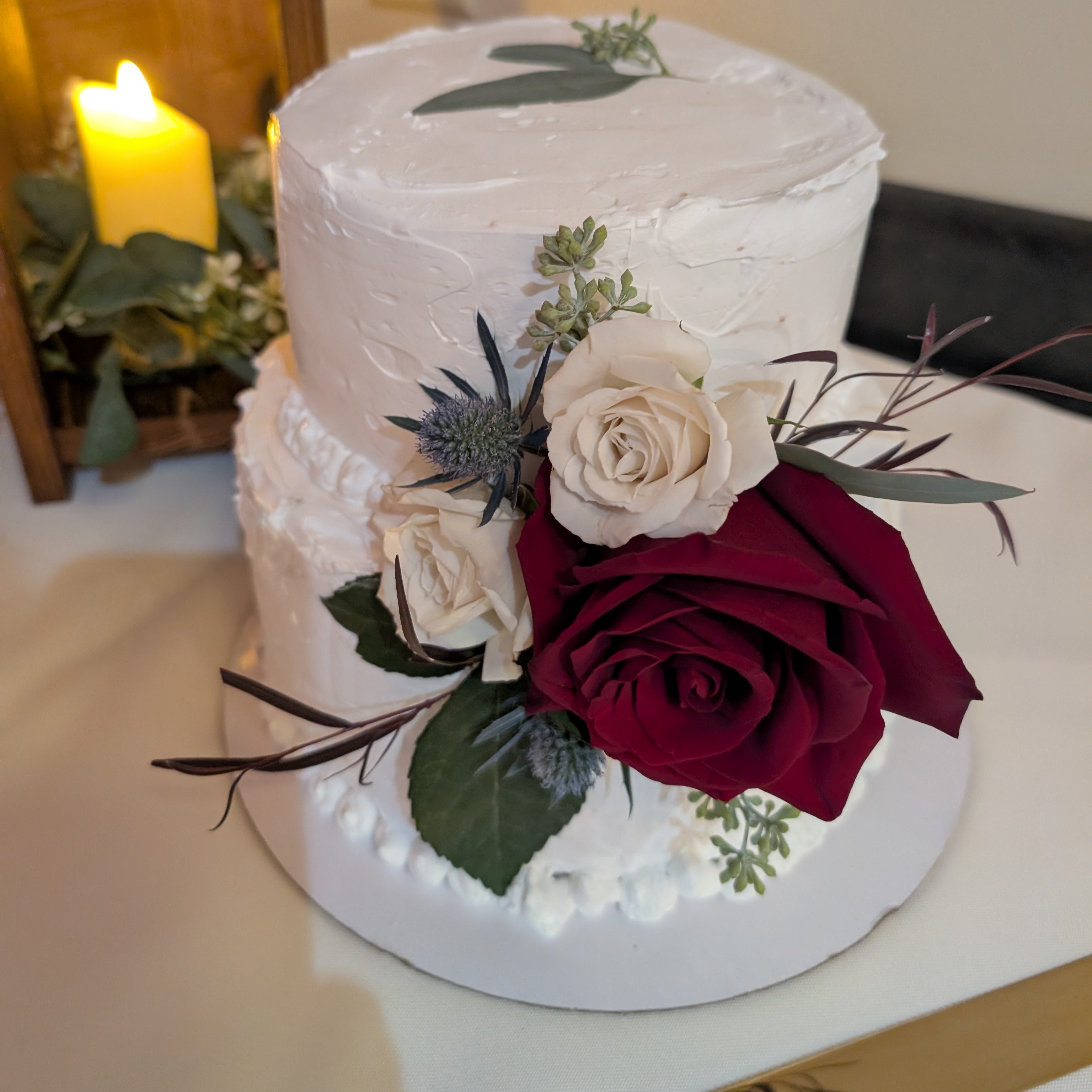 A frosted vegan wedding cake decorated with flowers.