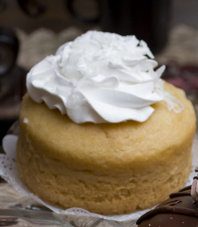 A coconut cupcake topped with shredded coconut.