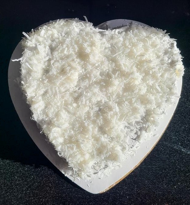 A gluten free coconut cake in the shape of a heart.